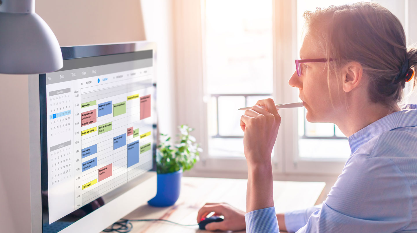 Calendrier mural avec dates annotées et entourées à la main, posé dans un bureau administratif éclairé naturellement