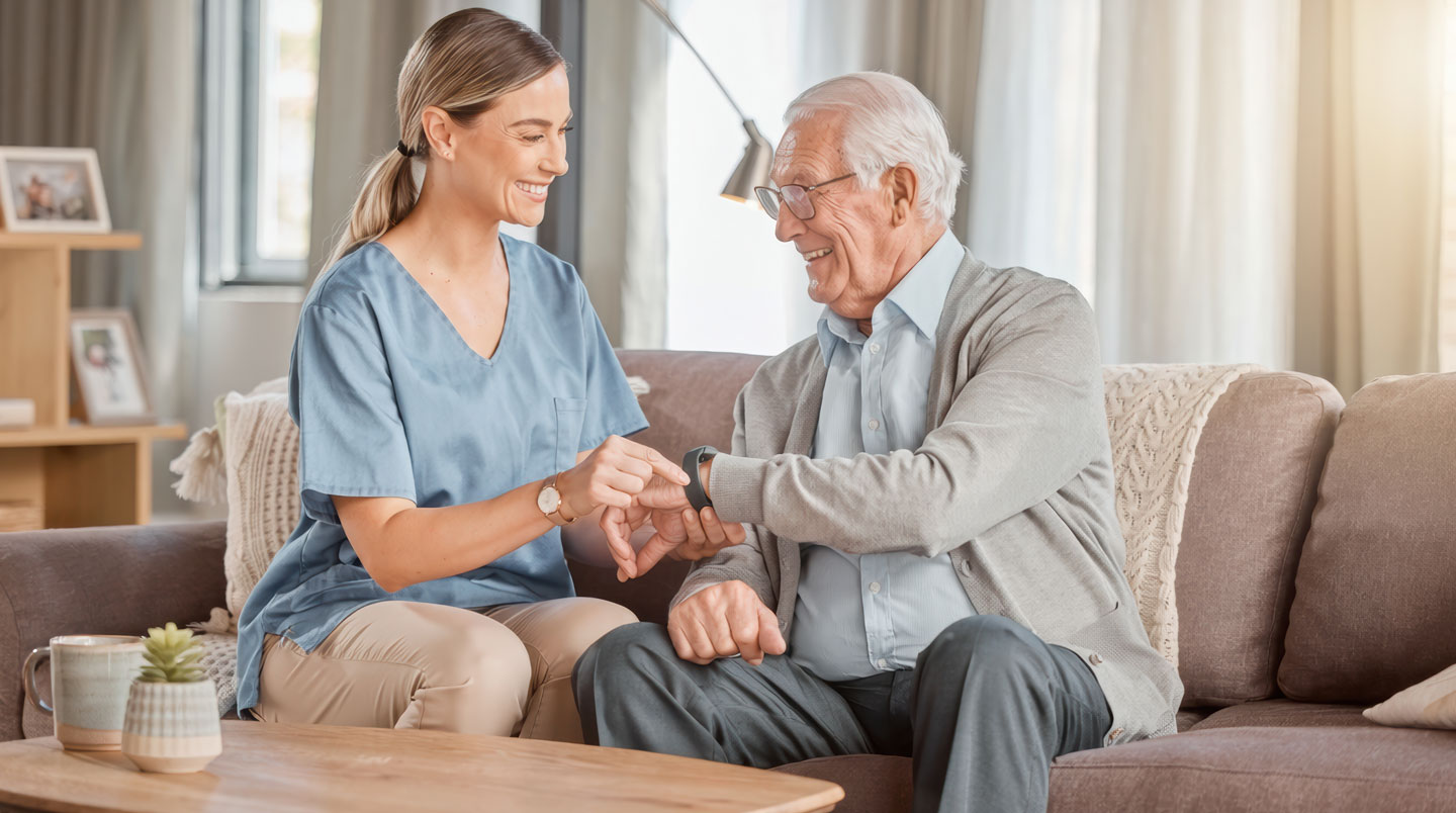 Bracelet connecté de téléassistance au poignet d'une personne âgée se déplaçant dans un couloir EHPAD équipé de balises de géolocalisation et de signalétique cognitive